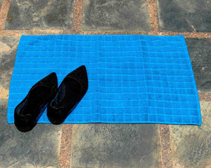 Laid out light blue cotton bath mat by Idaman Suri