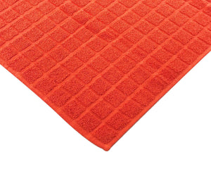 Opened orange cotton bath mat by Idaman Suri