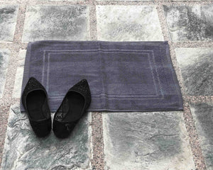 Laid out grey cotton bath mat by Idaman Suri